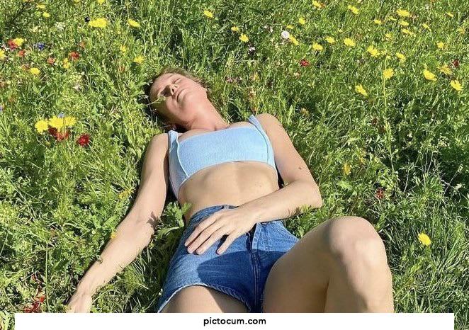Brie Larson showing off her body out in a field of flowers.