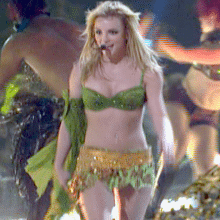 Britney Spears shaking it for us in a shiny green bra and short golden skirt