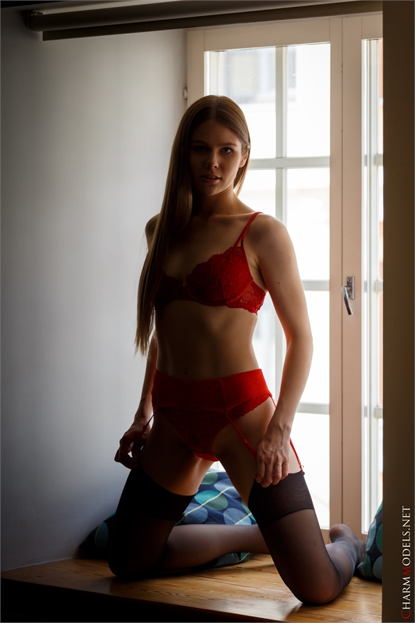 Evelina on the window in red lingerie charmmodels.net