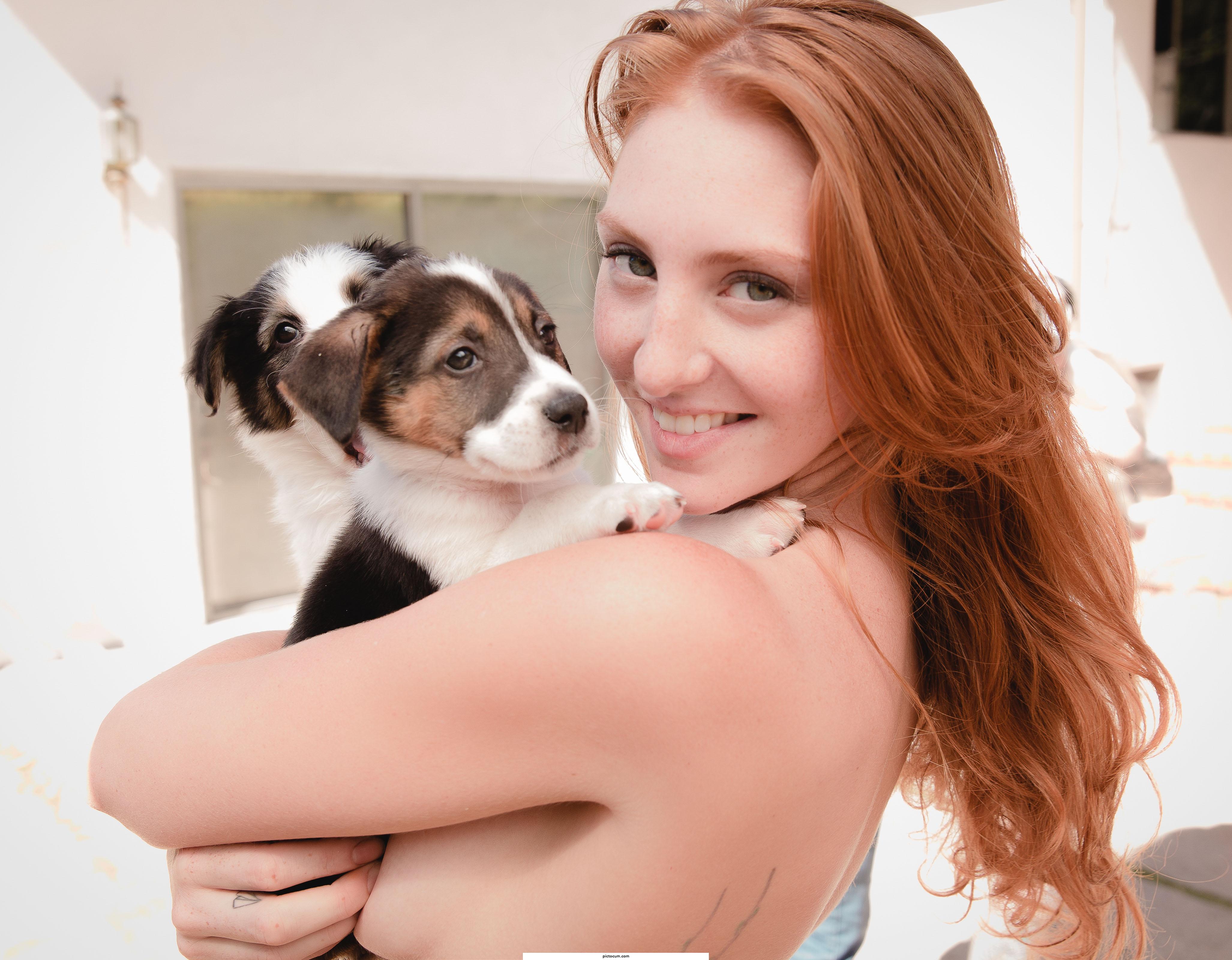 Freckled redhead holding puppies