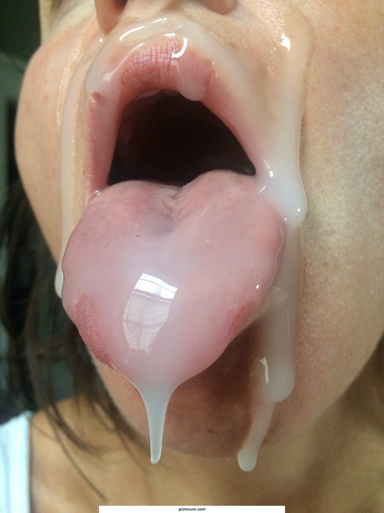 Amazing cum load facial, mouth open and tongue out, begging for more cum.